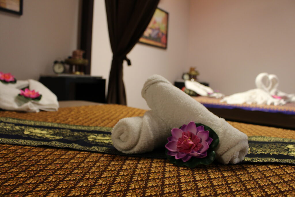 Opgerolde handdoek met lotusbloem op een massagebed